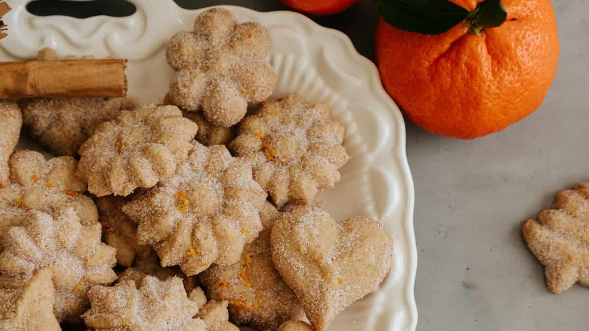 Biscochos recién horneados, con rebozo de canela y ralladura de naranja, en charola